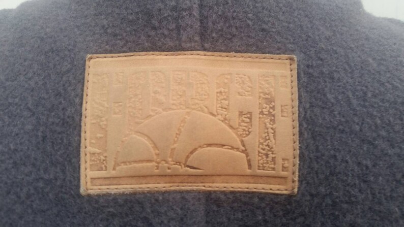 May include: A brown leather patch with the word "HURLEY" embossed in a stylized font. The patch has a stitched border and a design of a basketball inside a circle.