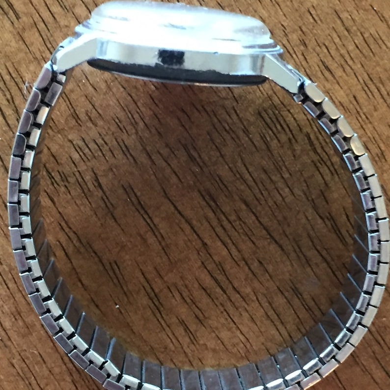 May include: A silver watch with a metal band. The watch face is not visible in the image.