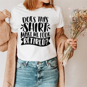 May include: White t-shirt with black text that reads "Does this shirt make me look retired?"