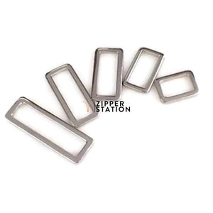 May include: Five silver metal D-rings of different sizes. The rings are arranged in a semi-circle shape.