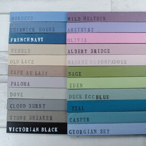 May include: A color chart with 16 paint colors, each with a name written in black text. The colors include: Moroccan, Chiswick House, French Navy, Pebble, Old Lace, Cafe au Lait, Paloma, Dove, Cloud Burst, Stone Breaker, Victorian Black, Wild Heather, Amethyst, Olivia, Albert Bridge, Madame Du Pompadour, Sage, Eden, Duck Egg Blue, Teal, Casper, and Georgian Sky.