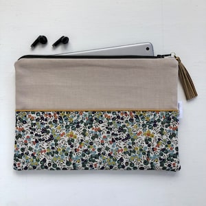 Peut inclure: Une pochette zippée en lin beige avec une doublure à imprimé floral. La pochette est dotée d'un pompon attaché au tirette de la fermeture éclair.
