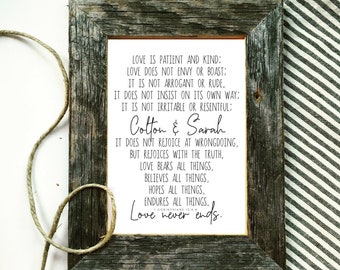 May include: A framed print with a rustic wooden frame. The print features a quote about love from 1 Corinthians 13:4-6. The quote is personalized with the names "Cotton & Sarah".