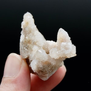 May include: A cluster of white quartz crystals with a rough, natural texture. The crystals are clustered together in a unique formation, creating a visually interesting piece.