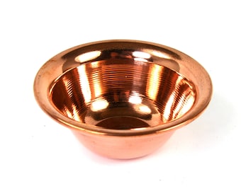 May include: A small, copper bowl with a shiny, reflective surface. The bowl has a slightly rounded bottom and a smooth, polished rim.