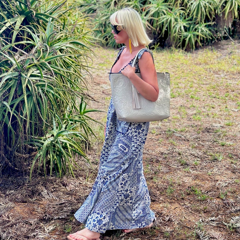 Handmade tooled leather tote bag for women with floral embossing, large zippered compartment, and boho-chic style. This personalized leather tote purse is perfect as a floral work bag or everyday handbag.