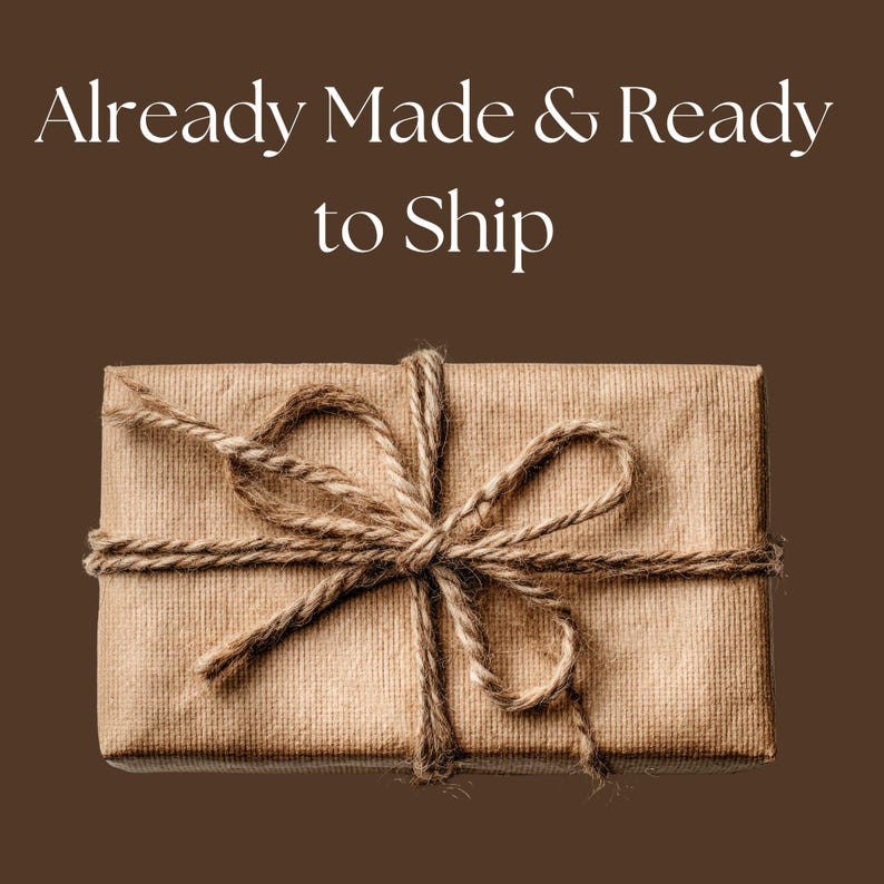 K&ouml;nnte beinhalten: Ein rechteckiges Paket, das in braunes Papier gewickelt und mit Bindfaden verschn&uuml;rt ist. Der Bindfaden ist oben zu einer Schleife geknotet. Der Text "Already Made & Ready to Ship" befindet sich oben im Bild.
