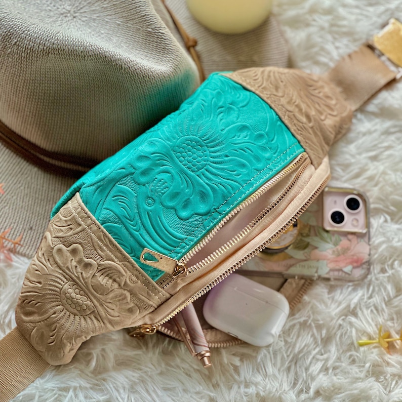 Handmade boho leather crossbody bag with floral embossing, adjustable strap, and fanny pack style. A versatile travel and concert bag, perfect as a Christmas gift or personalized gift for her or best friend.