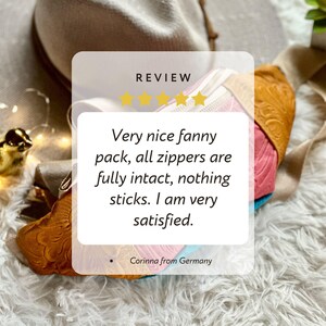 Op de afbeelding: Een veelkleurige heuptas met een gestructureerd, in reli&euml;f gemaakt bloemenpatroon in mosterdgeel, roze en lichtblauw, met een beige riem en een wit overlay-vak met de tekst: REVIEW, vijf sterren en de feedback van de klant.