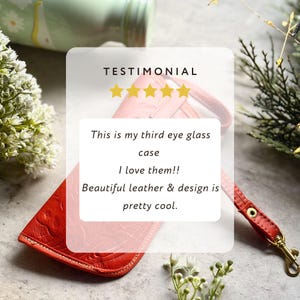 May include: A bright orange leather eyeglass case featuring an embossed floral pattern and a matching wrist strap with a gold-tone metal clasp. The case is displayed with a testimonial graphic that reads: This is my third eye glass case I love them!! Beautiful leather & design is pretty cool.