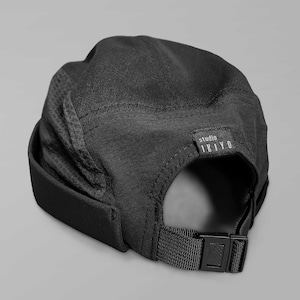 Peut inclure: Casquette de baseball noire en maille et nylon avec une sangle réglable et une étiquette noire avec du texte blanc qui indique "studio IKIYO"
