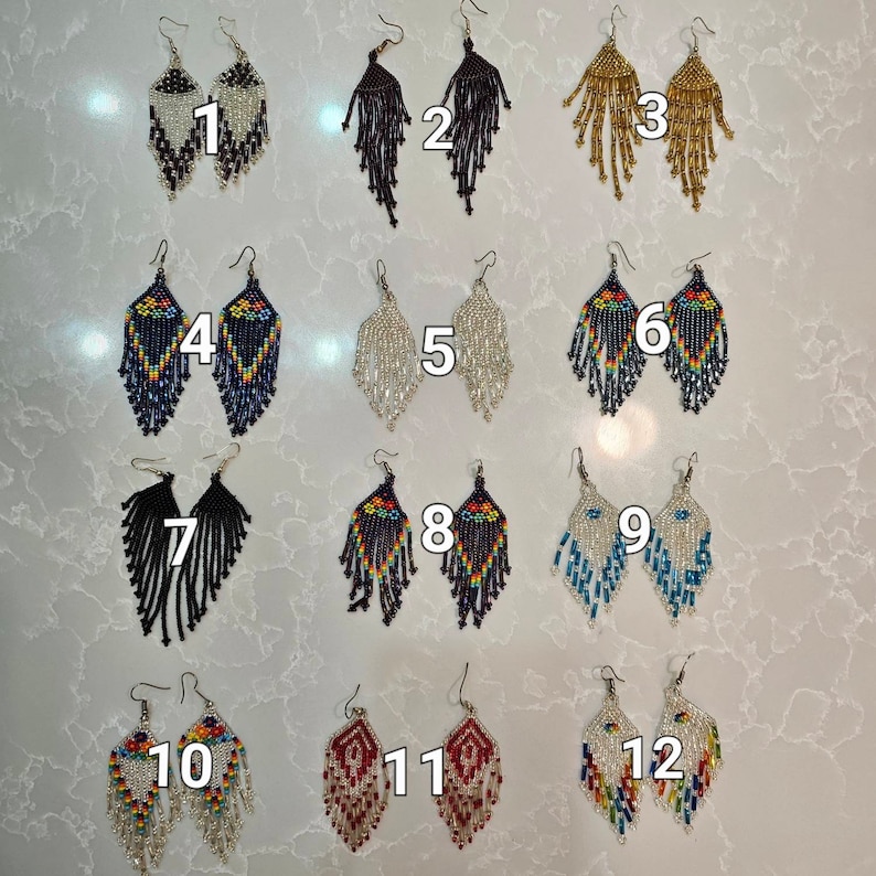 Peut inclure: Douze paires de boucles d'oreilles en perles, chaque paire est d'une couleur et d'un motif diff&eacute;rents. Les boucles d'oreilles sont toutes en forme de goutte et ont un crochet argent&eacute;.