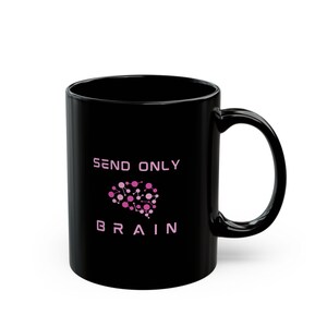 以下が含まれることがあります： ライトピンクの文字で「SEND ONLY BRAIN」と書かれた黒いセラミック製のマグカップ。「SEND ONLY」という文字の下には、ピンク色の円と線が繋がった脳のグラフィックがあり、その下にピンク色の文字で「BRAIN」と記されています。