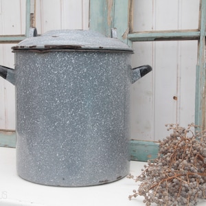 Puede incluir: Una olla grande de esmalte gris con tapa y dos asas negras. La olla tiene un acabado moteado, blanco y gris.