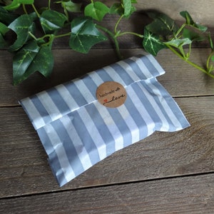May include: A gray and white striped paper bag with a brown circle sticker that says "handmade with love".