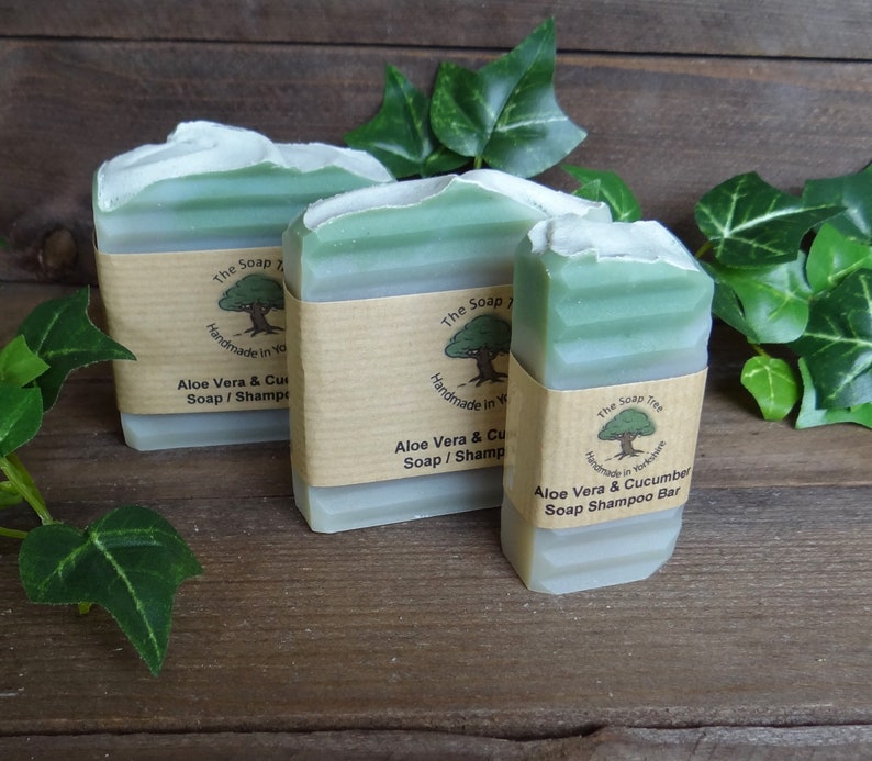 May include: Three bars of green soap with brown paper labels. The labels have a tree logo and the text "The Soap Tree", "Handmade in Yorkshire", "Aloe Vera & Cucumber Soap/Shampoo Bar".