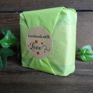 May include: A green gift bag with a brown circle sticker that says "handmade with love" and has red hearts around the text.