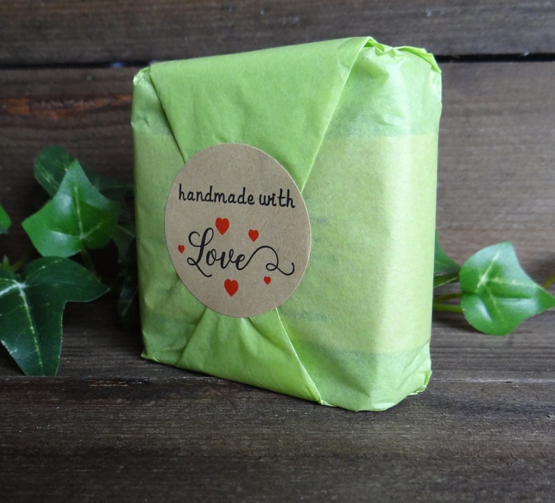 May include: A green gift bag with a brown circle sticker that says "handmade with love" and has red hearts around the text.