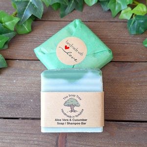 May include: A handmade Aloe Vera & Cucumber Soap/Shampoo Bar from The Soap Tree, wrapped in green paper with a "handmade with love" sticker. The soap has a light green and white color.