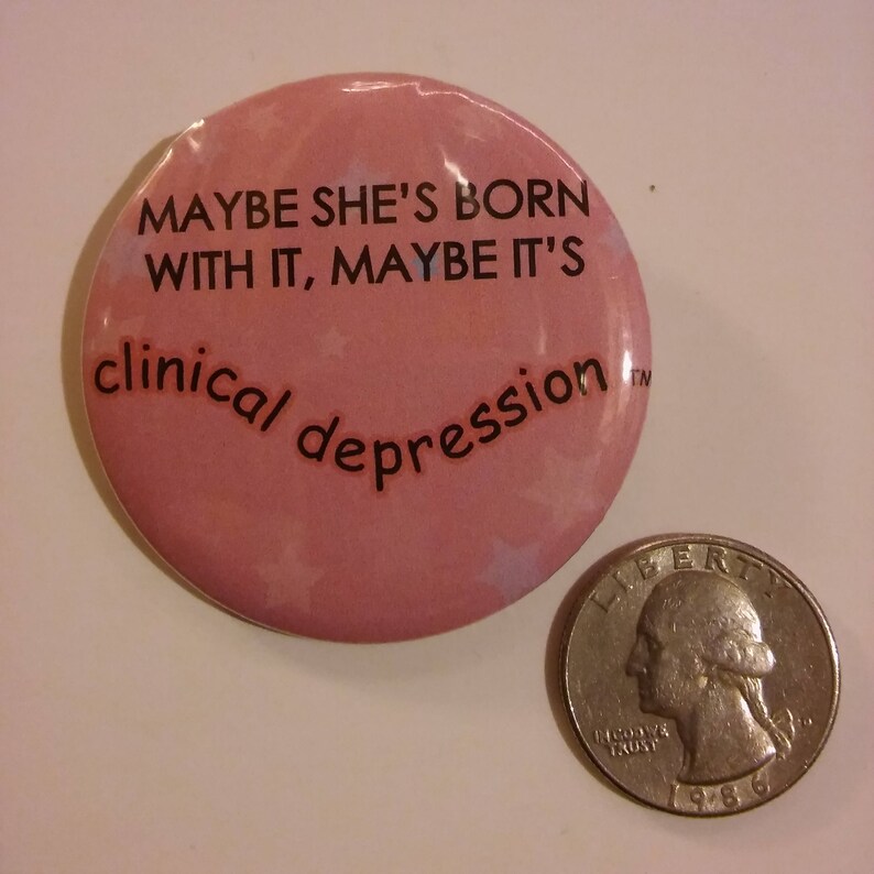 Puede incluir: Bot&oacute;n rosa con el texto "Maybe she's born with it, maybe it's clinical depression" en letras negras.