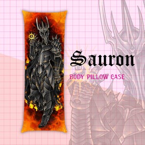 May include: Body pillow case with a detailed illustration of Sauron from The Lord of the Rings. The artwork shows Sauron in dark armour, holding a glowing orb, against a fiery background. Text on the pillow reads "Sauron BODY PILLOW CASE."