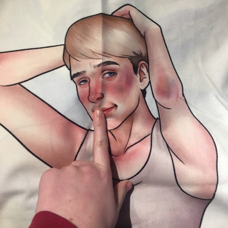 May include: A fabric print featuring a stylized illustration of a person with blonde hair and a light-colored tank top. The figure has flushed cheeks and a bruise on their elbow, with one hand raised behind their head and a finger held to their lips.