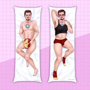May include: Two body pillow cases featuring a man in different poses. One pillow case shows the man wearing a black tank top and red underwear. The other pillow case shows the man holding a red and gold helmet. Both pillow cases have a white background.