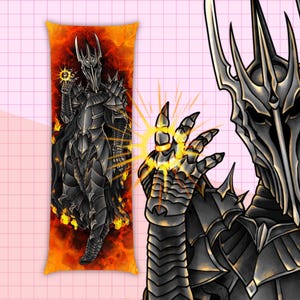 May include: A body pillow featuring a detailed illustration of a dark armored figure with a crown, holding a glowing orb. The background is a fiery orange and red. The figure is also depicted in a separate illustration.