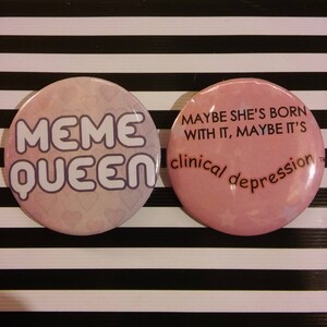 Puede incluir: Dos pines de bot&oacute;n rosas con texto blanco. El primer pin dice "Meme Queen" y el segundo pin dice "Maybe she's born with it, maybe it's clinical depression."