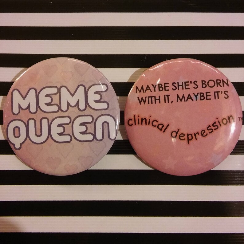 Puede incluir: Dos pines de bot&oacute;n rosas con texto blanco. El primer pin dice "Meme Queen" y el segundo pin dice "Maybe she's born with it, maybe it's clinical depression."