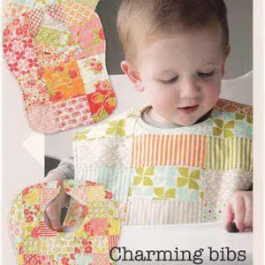 May include: A patchwork baby bib with a floral and geometric pattern in shades of pink, orange, green, and white. The bib is made of fabric squares sewn together. The text "Charming bibs" is at the bottom.