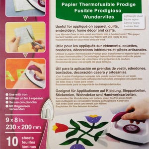 May include: A package of 10 sheets of Wonder Fuse fusible web, a heat-activated adhesive for crafts. The package is green and white with images of the product being used for applique and quilting. The text on the package reads "Wonder Fuse Papier Thermofusible Prodige Fusible Prodigioso Wundervlies".
