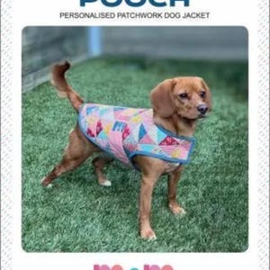 May include: A brown dog wearing a patchwork dog jacket with a blue trim. The jacket is made of pink, blue, and yellow geometric shapes. The text "PERSONALISED PATCHWORK DOG JACKET" is at the top of the image.