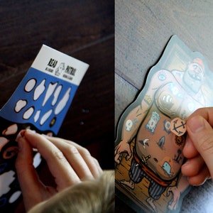 May include: A sticker activity set featuring a cartoon pirate with a variety of tattoos. The set includes a sheet of stickers with different designs, including an anchor, a whale, and a skull. The stickers can be placed on the pirate's body to create a unique look.