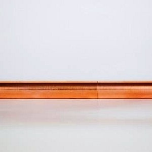 May include: A copper-coloured pen, cylindrical in shape, with rounded ends. The pen is made of a shiny, metallic material and appears to be a writing instrument. The pen is approximately 15 cm long.