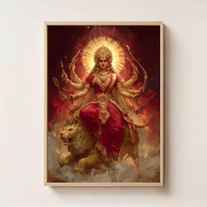 May include: A framed print showing a multi-armed deity in a red sari, wearing gold jewellery and a crown, riding a lion. The artwork has a golden halo and a fiery red background, creating a vibrant and spiritual aesthetic.