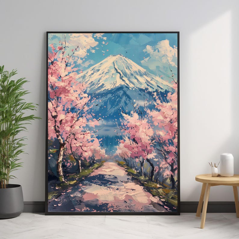 Pode incluir: Pintura emoldurada que retrata o Monte Fuji no Jap&atilde;o. A obra de arte apresenta uma montanha coberta de neve, um caminho e cerejeiras em flor. A paleta de cores inclui tons de azul, rosa e branco.