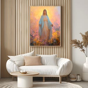 May include: A framed painting of a woman in a light blue robe, standing in a field of flowers. The artwork has a soft, ethereal quality with warm yellow and orange hues in the background. The painting is displayed above a white sofa with a round wooden coffee table.