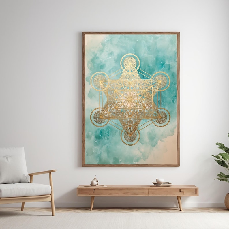 Pu&ograve; includere: Stampa artistica incorniciata con un design dorato del Cubo di Metatron su uno sfondo acquerello turchese e beige. L'opera d'arte &egrave; esposta in una stanza con un tavolino in legno e una sedia bianca.