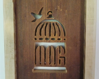 Wooden wall art of a bird and cage from reclaimed wood