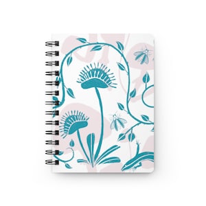 Puede incluir: Una libreta de espiral blanca con un diseño floral rosa y turquesa. El diseño presenta un patrón repetitivo de flores turquesas, enredaderas y polillas.