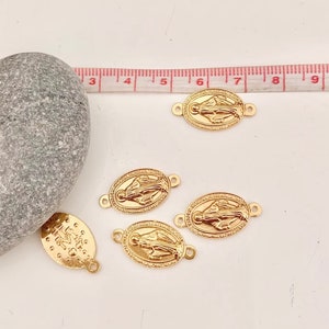 Peut inclure: Cinq breloques en métal doré représentant une image religieuse de la Vierge Marie. Les breloques ont deux anneaux de saut pour les attacher à des bijoux ou d'autres objets artisanaux.