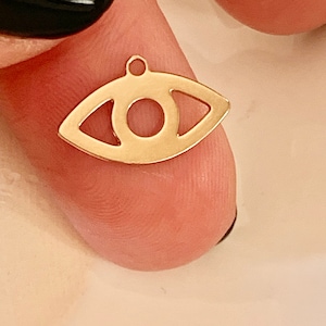 Peut inclure: Breloque en métal doré en forme d'œil. L'œil a un petit trou en haut pour l'attacher à un collier ou un bracelet.