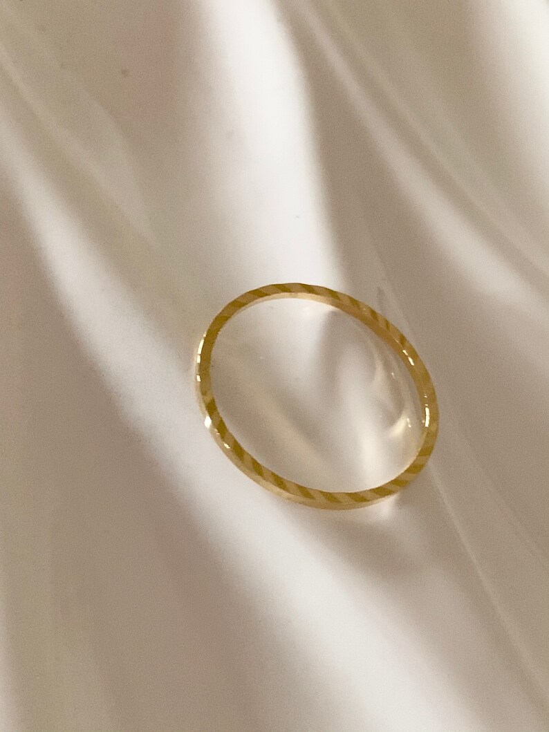 Puede incluir: Un fino anillo de banda de oro con un patr&oacute;n texturizado diagonal.