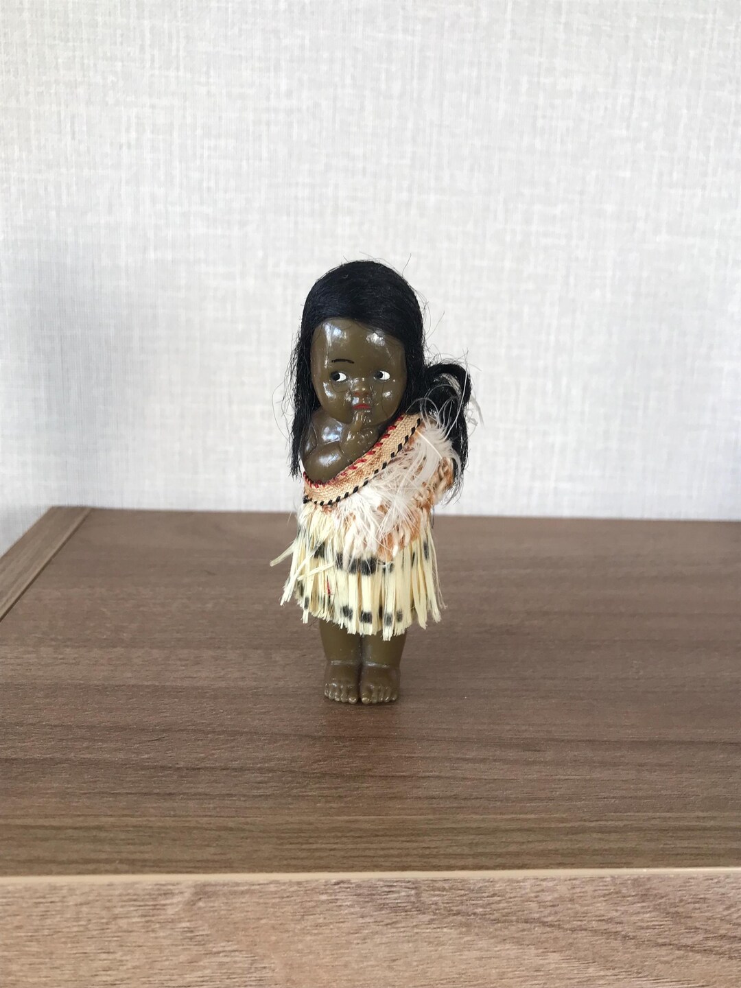 草のスカートと羽根飾りをつけた小さなヴィンテージセルロイド製黒人