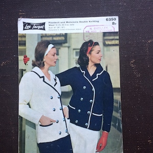 May include: A vintage knitting pattern booklet featuring two women wearing white and navy blue jackets. The pattern is for Fleetknit and Motoravia Double Knitting, using 18 (19; 20) 2-oz. balls of wool. The pattern is for a bust size of 34" (30; 38"). The booklet is titled "Lee Target" and has a price of 8d.