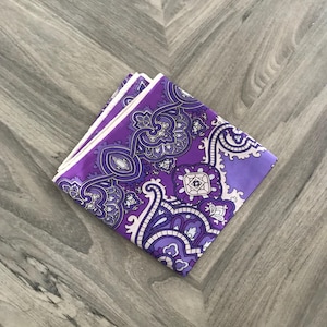 May include: A purple and white paisley patterned silk scarf folded in half.