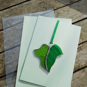 Attrape-soleil en forme de feuille de lierre en verre teinté, sur une carte de voeux vierge