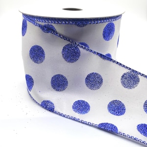 May include: White ribbon with blue glitter polka dots. The ribbon has a wired edge.
