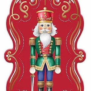 May include: A decorative wall hanging featuring a nutcracker illustration on a red, scalloped-edge plaque. The nutcracker wears a green jacket, blue trousers, and a red hat, holding a silver sword. Gold scrollwork accents the red background.